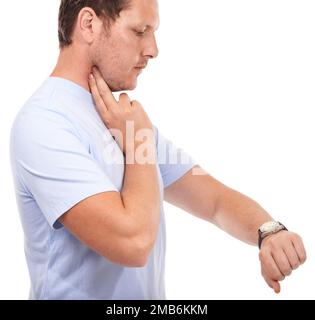 Surveillance de sa fréquence cardiaque. Jeune homme prenant son rythme cardiaque sur fond blanc. Banque D'Images