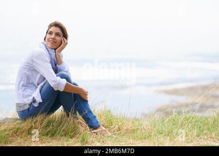 Imprégnez-vous de la vue. Une femme mûre prenant une pause de sa promenade pour admirer le paysage. Banque D'Images