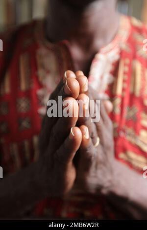 Africain priant dans une église les menuttes. Cotonou. Bénin. Afrique. Afrique de l'Ouest. / Prier dans une église mains jointes. Cotonou. Bénin. Banque D'Images