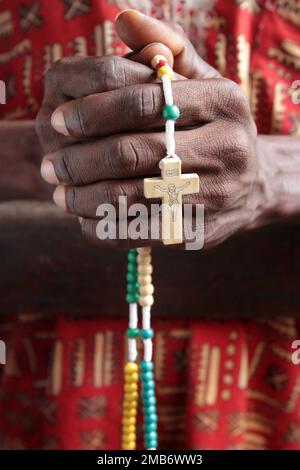 Africain priant dans une église avec un chapelet. Cotonou. Bénin. Afrique. Afrique de l'Ouest. / L'Afrique priant dans une église avec un rosaire. Cotonou. Banque D'Images