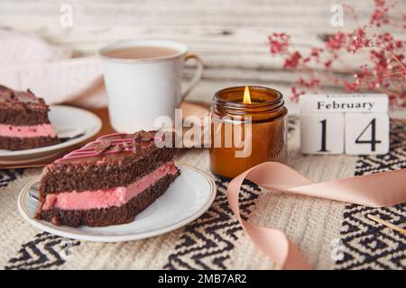 Desserts festifs délicats de la Saint-Valentin - morceaux de gâteau au chocolat et aux cerises, tasses à café et texte 14 de l'esthétique de février. Banque D'Images