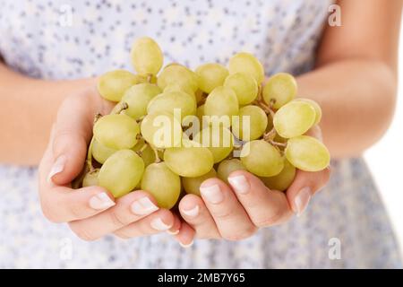 Les raisins sont grands. Image rognée d'une main de womans tenant un bouquet de raisins. Banque D'Images