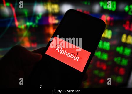 Dans cette illustration, le logo Alphabet de Google affiché sur un smartphone avec bourse en arrière-plan. Banque D'Images