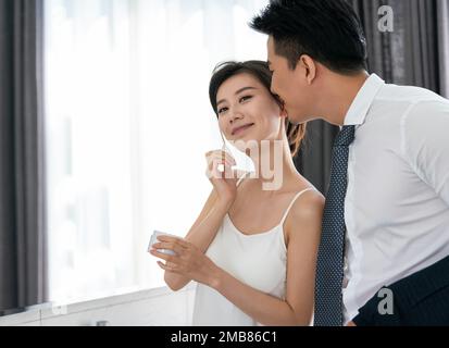 Le jeune couple regarde dans le miroir avant d'aller au travail Banque D'Images