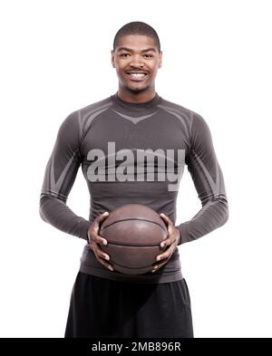 Le basket-ball me fait toujours sourire. Portrait d'un beau jeune joueur de basket-ball debout dans le studio. Banque D'Images