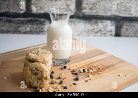 Délicieux petits gâteaux frais avec lait dans une bouteille en verre. Banque D'Images