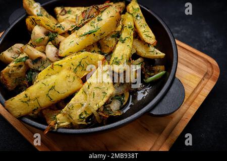 Pommes de terre frites avec champignons, oignons et aneth dans une casserole Banque D'Images