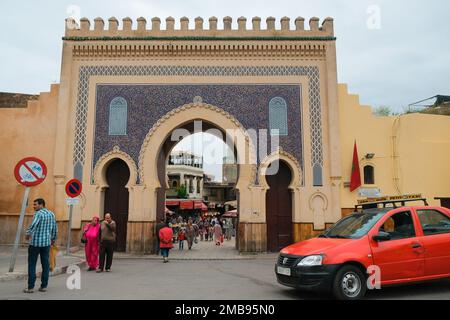 Fès, Maroc - Grand porte de la ville Bab Bou Jeloud à Fès el Bali. Entrée française monumentale. Petit taxi rouge garé à l'extérieur de l'ancienne médina. Repère FES. Banque D'Images