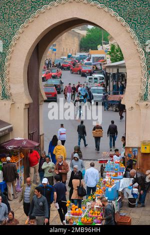 Fez, Maroc - vue à travers la grande porte de la ville Bab Bou Jeloud de l'intérieur de l'ancienne Fes el Bali medina. Entrée française monumentale. Personnes, petits taxis sur Banque D'Images