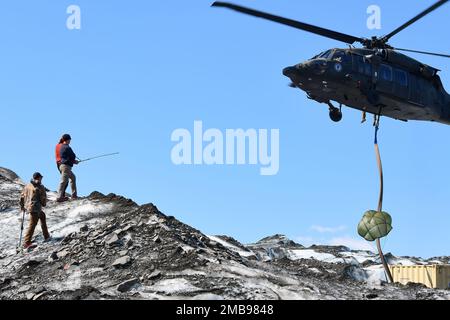 Un hélicoptère Black Hawk de la Garde nationale de l'Alaska transporte un conteneur pour l'entreposage de pièces d'aéronef récupérées sur Colony Glacier 13 juin 2022, dans le cadre de l'équipe qui travaille à récupérer les restes de 52 passagers et membres d'équipage, Et l'épave d'un avion Globemaster C-124 de la Force aérienne qui s'est écrasé le 22 novembre 1952, près du mont Gannet, en Alaska. Des soldats affectés à la Garde nationale de l'Armée de l'Alaska ont découvert les débris sur 10 juin 2012, au cours d'une mission d'entraînement en hélicoptère de routine de la Faucon noire sur le glacier de Colonia à près de 14 milles d'où l'avion s'est écrasé pour la première fois. (Photo de l'armée/John Pennell) Banque D'Images