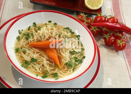 Bouillon clair servi avec des carottes, des nouilles et du persil. Banque D'Images