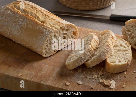 Gros plan sur une planche à découper avec du pain et des tranches de ciabatta frais traditionnels italiens Banque D'Images