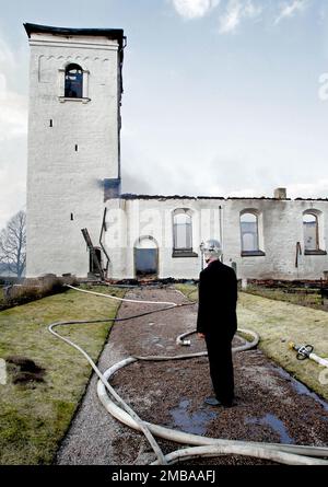 Un incendie dans un atelier à l'heure du déjeuner jeudi a eu des conséquences dévastatrices pour l'église d'Älvestad entre Klockrike et Fornåsa dans la municipalité de Motala, en Suède. Le feu s'est propagé au toit de l'église d'Älvestad, dont les parties les plus anciennes datent du 12th siècle. L'église a été complètement détruite et deux personnes ont été blessées dans l'incendie, dont un pompier. Sur la photo: Mgr Martin Lind sur la scène du feu. Banque D'Images