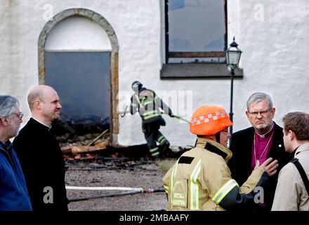 Un incendie dans un atelier à l'heure du déjeuner jeudi a eu des conséquences dévastatrices pour l'église d'Älvestad entre Klockrike et Fornåsa dans la municipalité de Motala, en Suède. Le feu s'est propagé au toit de l'église d'Älvestad, dont les parties les plus anciennes datent du 12th siècle. L'église a été complètement détruite et deux personnes ont été blessées dans l'incendie, dont un pompier. Sur la photo: Mgr Martin Lind (à droite sur la photo) sur la scène du feu. Banque D'Images
