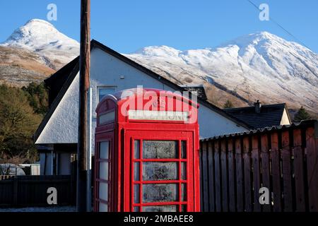 Glencoe village, Écosse, Royaume-Uni. 20th janvier 2023. La boîte téléphonique dépolie et le ciel bleu clair, le soleil et les pistes enneigées de la magnifique montagne Pap of Glencoe à Glencoe offrent une toile de fond pour les conditions de conduite difficiles sur la route principale glacée A82 au nord. Crédit : Craig Brown/Alay Live News Banque D'Images