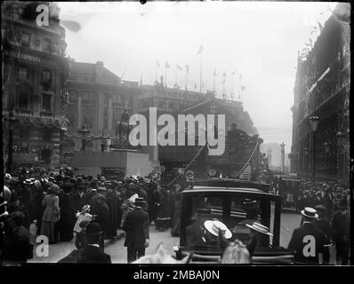 Bank, City and County of the City of London, Greater London Authority, 1911. Une vue de l'extérieur de la Banque d'Angleterre sur Threadneedle Street vers Mansion House, montrant un carrefour de Bank Road rempli de gens et de circulation. Prise par le photographe pour présenter les décorations du couronnement à Londres. Il y a des drapeaux et des banderoles décorant les bâtiments autour de la jonction Bank Road. Banque D'Images