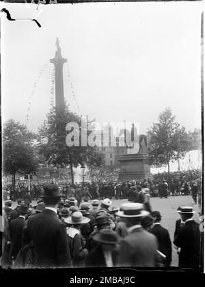 Trafalgar Square, St James, Westminster, City of Westminster, Greater London Authority, 1919. Vue des marches de l'église Saint-Martin-dans-les-champs vers une grande foule de personnes rassemblées à Trafalgar Square pour acheter des obligations de prêt de la victoire. Après la première Guerre mondiale, le gouvernement britannique était lourdement endetté et l'une des manières dont ils ont collecté de l'argent était de vendre des obligations de prêt et des certificats Victory au public. Lors de cet événement, des tentes ont été érigées à Trafalgar Square avec des banderoles et des slogans patriotiques attachés à la colonne de Nelson pour annoncer la vente des obligations. Cette photo est l'une des photos d'un groupe Banque D'Images