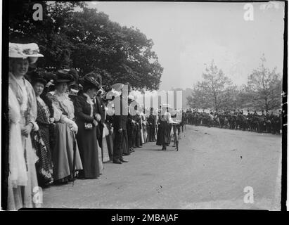 Hyde Park, Cité de Westminster, Autorité du Grand Londres, 1907. Une vue le long d'une promenade en calèche dans Hyde Park montrant des spectateurs, un policier et une fille avec un vélo à un club d'entraînement se rencontrent. Dès le début de 1800s, pendant la saison de Londres, les membres des clubs d'entraînement se sont réunis à Hyde Park avant de partir pour déjeuner à des endroits tels que Crystal Palace, Greenwich ou Richmond. Banque D'Images