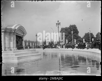 Queen Victoria Memorial, The Mall, St James, City of Westminster, Greater London Authority, 1919. En regardant de l'autre côté de l'eau dans la fontaine du Queen Victoria Memorial vers les gens assis tout autour de lui. Cette photo fait partie d'un groupe que le photographe a pris sur les 18th, 21st et amp ; 23rd juillet 1919, enregistrant les décorations de paix qui avaient été érigées à Londres pour la Journée de la paix et la victoire Mars, 19th juillet 1919, pour célébrer la fin de la guerre mondiale 1. Banque D'Images