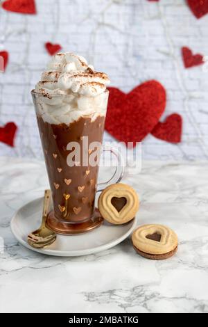 Tasse de chocolat avec crème et biscuits avec coeurs sur fond de coeurs sur marbre blanc Banque D'Images