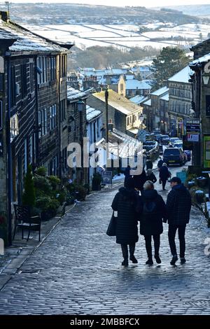 Personnes sur la rue principale de Haworth dans la neige d'hiver, West Yorkshire Banque D'Images