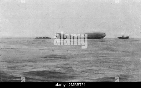 'Le Zeppelin "L-15" abattu dans l'estuaire de la Tamise; le "L-15" photographie au petit jour, le !er avril, tandis qu'on essayait du remorquant vers la côte du Come de Kent. Un peu plus tard, la brisure s'accentua, le milieu s'enfonca et le plat digilable par couler', 1916. De "Collection de la guerre IV L'Illustration Tomé CXLVII. La guerre janvier, Fevrier, Mars, avril, Mai, Juin 1916". Banque D'Images