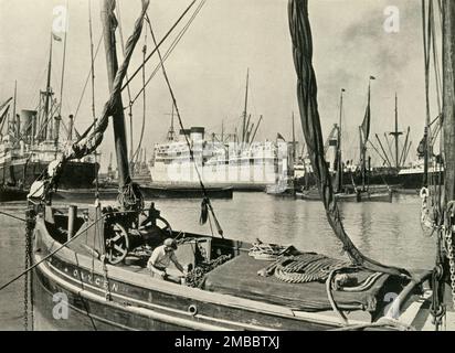 "Allez sous les ponts dans l'un des lancements de l'autorité du port de Londres et visitez Dockland" Shipping in the Royal Albert Dock, 1937. Bateaux et péniches sur la Tamise à Londres. De "la rivière Said Noble", par Alan Bell. [Administration du port de Londres, Londres, 1937] Banque D'Images