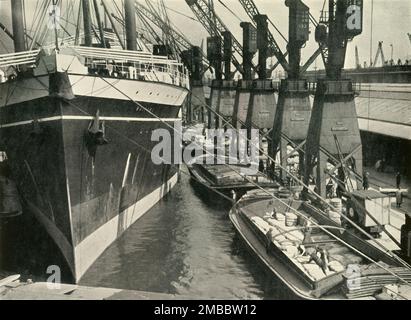 "Marchandises de tout genre trouver ici les installations appropriées pour le déchargement, l'entreposage et la distribution" South Quay, Royal Albert Dock, 1937. Grues sur la Tamise à Londres. De "la rivière Said Noble", par Alan Bell. [Administration du port de Londres, Londres, 1937] Banque D'Images