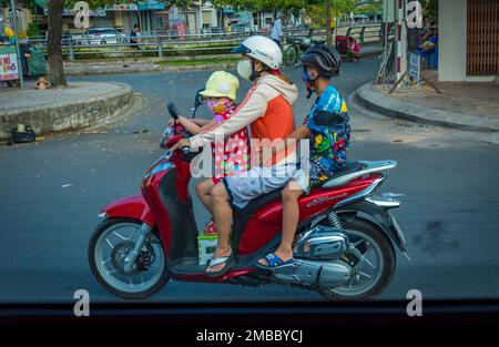 Père avec deux 2 fils à cheval sur un Moped en asie vietnam. Banque D'Images