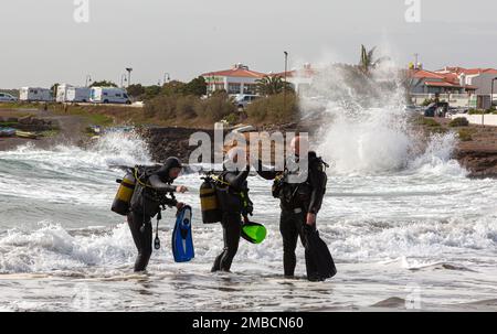 Un groupe de personnes en costume de plongée se trouve sur la côte de l'océan Atlantique. Ténérife, Îles Canaries, Espagne. Banque D'Images
