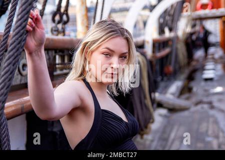 Hayleigh Young, une belle et à la mode femme pose pour la photographie à bord du navire RRS Discovery par une journée hivernale glaciale à Dundee, en Écosse Banque D'Images