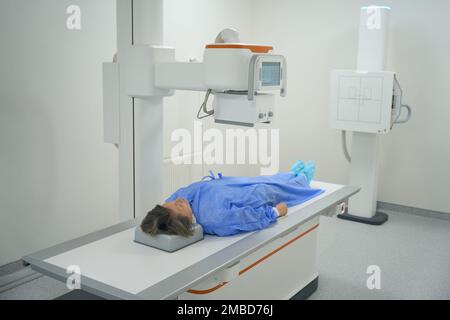 Le patient se trouve sur une table spéciale dans la salle de diagnostic à rayons X. Banque D'Images