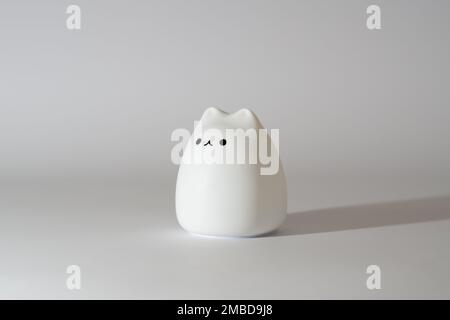 Lampe en forme de chat blanche sur fond blanc. Jolie lampe en silicone en forme de chat sur fond blanc. Banque D'Images