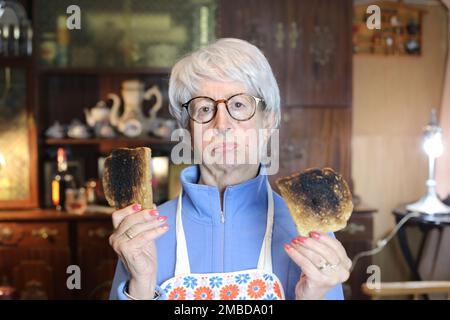 Femme âgée déçue portant des toasts brûlés Banque D'Images