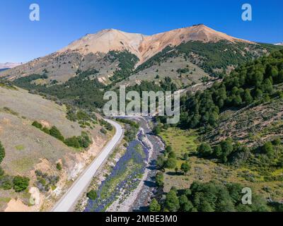 Vue aérienne de la Carretera Austral avec une crique cristalline le long de la route et des collines et montagnes boisées en Patagonie, au Chili Banque D'Images