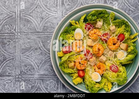 Photographie alimentaire de salade césar, crevettes, crevettes, romaine, laitue, œuf de caille, parmesan, croûtons Banque D'Images