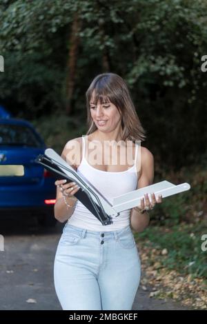 femme d'affaires mettant un triangle d'avertissement sur la route. Voiture cassée. Accident avec une auto. Banque D'Images