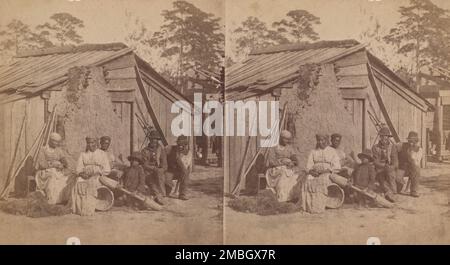 Groupe familial assis devant une cabane en bois, (1868-1900?). Banque D'Images