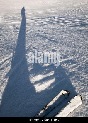 une ombre allongée d'un skieur sur la neige d'une piste de ski, verticale Banque D'Images