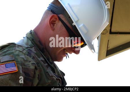 Jesse Greene, ingénieur de la compagnie 389th Engineer, se prépare à visser la voie d'évitement en métal dans le cadre d'un projet visant à améliorer les zones d'entraînement à fort McCoy, Wisconsin, 16 juin 2022. Les ingénieurs travaillent à rendre les bâtiments de la base d'entraînement tactique courage plus frais et mieux à même de s'adapter aux diverses conditions météorologiques ici, ainsi qu'à améliorer les routes autour de la zone d'entraînement. Banque D'Images