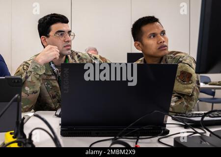 ÉTATS-UNIS Air Force Airman 1st classe Michael Delado, à gauche, Cyber Operations affecté à l'aile Airlift 103rd, à la Garde nationale aérienne du Connecticut et aux États-Unis Le lieutenant Rithy Heng de la Force aérienne 2nd, à droite, un officier des opérations informatiques affecté à la 103rd Escadre du transport aérien, Garde nationale aérienne du Connecticut, regarde vers un moniteur d'ordinateur à Camp Net, Niantic, Connecticut, 16 juin 2022. Les deux aviateurs font partie du 103rd Air Control Squadron, qui, en plus de fournir des capacités de communications et de contrôle de l'espace aérien, permet de mener des opérations informatiques à leur siège supérieur, le 103rd Airlift Wi Banque D'Images