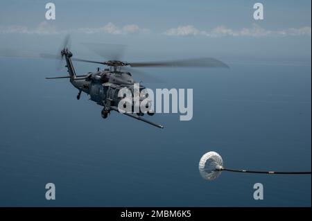 Un hélicoptère HH-60G Pave Hawk est ravitaillé par un escadron de sauvetage HC-130J combat King II du 39th e Escadron lors d'une compétition de tir de dinde au large de la Floride sur 16 juin 2022. Au cours de la compétition, les membres de l'équipage ont concouru sur des compétences telles que l'emploi d'armes d'avion, le ravitaillement en vol d'hélicoptère, la navigation dégradée, la recherche dégradée et le hissage confiné. Banque D'Images