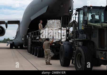 Les membres du service de la Force opérationnelle interarmées-Bravo de l'escadron 612th de la base aérienne déchargent un C-17 Globemaster III de la base conjointe Charleston, Caroline du Nord, 17 juin 2022, à la base aérienne Soto Cano, au Honduras. Le C-17 a livré sept palettes de produits donnés dans le cadre du programme Denton. Le programme Denton permet aux citoyens et aux organisations privées des États-Unis d'utiliser l'espace disponible sur les avions de fret militaires américains pour transporter des marchandises humanitaires vers des pays approuvés dans le besoin. (É.-U. Photos de la Force aérienne par Tech. Sgt. Amber carter) Banque D'Images