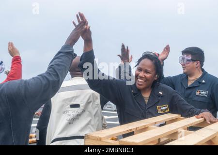 220617-N-VF045-1153 OCÉAN PACIFIQUE NORD (17 juin 2022) Spécialiste en logistique en chef Okeisha Daily, de Wilmington, Delaware, marins de haut-fives après avoir terminé une reconstitution verticale sur le pont de vol à bord du destroyer de missile guidé de classe Arleigh Burke USS Milius (DDG 69). Milius est affecté à la Force opérationnelle 71/Escadrier Squadron (DESRON) 15, la plus importante force de surface déployée à l’avant de la Marine et la principale force de surface de la flotte américaine 7th. Banque D'Images