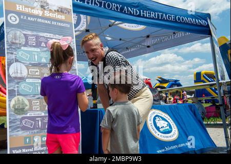 Millington, Tennessee (18 juin 2022) mécanicien de construction Damian M. Persanl, originaire de Mt. Sherman, Kentucky, affecté à l'USS Constitution, parle aux enfants de l'histoire de la Marine au stand du Navy History and Heritage Command au Midsuth Airshow pendant la Navy week de Memphis. La Memphis Navy week est l'une des 14 Navy Weeks de 2022, qui apporte une variété d'actifs, d'équipement et de personnel à une seule ville pour une série d'engagements d'une semaine conçus pour rapprocher la Marine américaine des gens qu'elle protège. Chaque année, le programme touche plus de 140 millions de personnes -- environ Banque D'Images