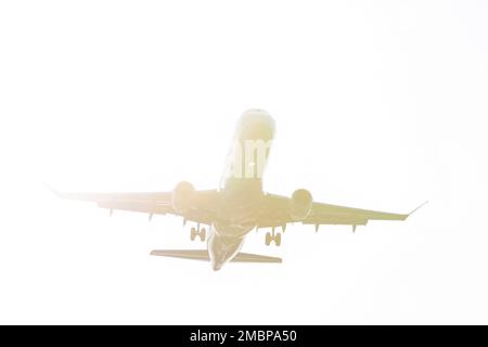 Un avion de ligne est silhoueté par le soleil lorsqu'il arrive pour un atterrissage à l'aéroport international de Seattle-Tacoma à SeaTac, Washington, mardi, 1 janvier Banque D'Images