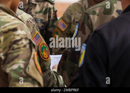 ÉTATS-UNIS Les soldats de l'armée affectés au Groupe des forces spéciales (aéroporté) de 19th, à la Garde nationale de l'armée de l'Utah, aux soldats de l'armée royale marocaine et aux parachutistes de l'armée de terre tunisienne discutent des derniers détails du matin de l'opération aéroportée par l'amitié à Grier Labouihi, au Maroc, pendant le Lion africain 22, au 19 juin 2022. African Lion 22 est américain Le plus grand exercice annuel combiné, conjoint, du Commandement de l'Afrique organisé par le Maroc, le Ghana, le Sénégal et la Tunisie, 6 juin - 30. Plus de 7 500 participants de 28 pays et de l'OTAN s'entraînent ensemble en mettant l'accent sur l'amélioration de la préparation des forces américaines et des pays partenaires. A Banque D'Images