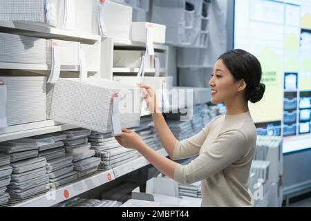 La jeune femme de choisir et d'acheter des articles ménagers Banque D'Images