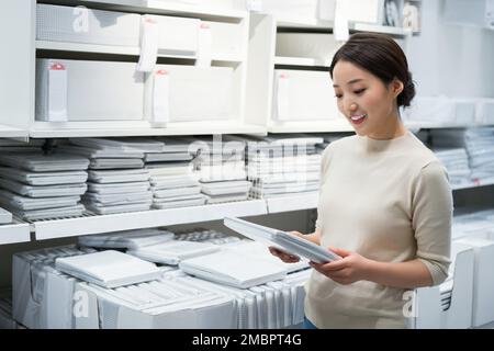 La jeune femme de choisir et d'acheter des articles ménagers Banque D'Images