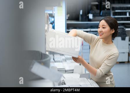 La jeune femme de choisir et d'acheter des articles ménagers Banque D'Images